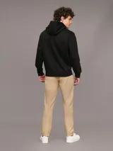 Pantalón chino color beige confeccionado en sarga de algodón elástica suave, de corte regular y pierna estrecha en el tobillo.