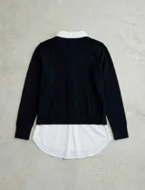 Buzo de hilado fino color beige con cuello y ruedo de gasa blanca que simula una camisa debajo. Presenta escote en V y mangas largas.