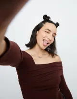 Collar plateado con cadena fina y dije central de mosquetón entrelazado.