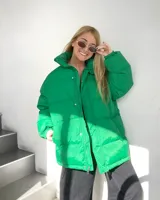 Campera puffer verde, de corte oversize, con cuello alto y cierre frontal con botones a presión y cremallera.