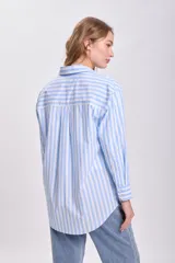 Camisa celeste con rayas verticales blancas, de corte oversize y manga larga.
