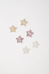 Pack de tres hebillas para el pelo con forma de estrella hueca, en colores blanco, rosa y beige.