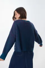 Sweater de punto grueso a rayas verticales en color azul petróleo y borgoña, de corte holgado y mangas largas.