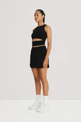 Falda de tennis negra con short interno, confeccionada en tejido de alta torsión.