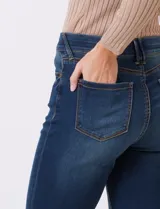 Jean elastizado de mezclilla azul oscuro, tiro alto, con pierna bootcut. Presenta costuras visibles y cinco bolsillos.