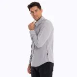 Camisa manga larga color verde oliva, confeccionada en poliéster y spandex. Cuenta con cuello camisero, cierre con botones, bolsillo en el pecho y protección solar UPF 50+.