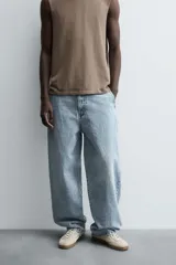 Pantalón de denim de algodón, color celeste claro lavado, de corte relaxed fit con tiro alto, bolsillos frontales y bolsillos traseros de plastrón.