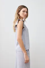 Blusa gris melange sin mangas con volados en los hombros y vivo metálico.