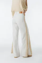Pantalón palazzo color beige con detalles de crochet en los laterales.