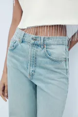 Pantalón de jean azul de corte wide leg, tiro alto y largo hasta el tobillo.