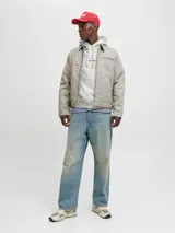 Buzo con capucha y bolsillo canguro, de manga larga y calce relajado. Tejido loopback con interior cepillado. Color gris melange jaspeado, con inscripción pequeña en el pecho.