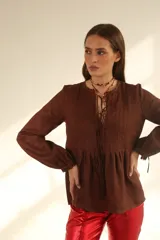 Blusa color chocolate de lino con cuello redondo y lazo ajustable.