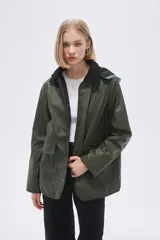 Campera verde militar con capucha, cierre frontal con botones a presión y bolsillos con solapa. Cuello de pana color negro.
