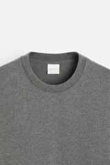 Camiseta gris de algodón, corte recto, cuello redondo y manga corta.