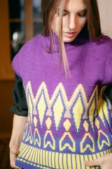 Chaleco de punto morado con cuello alto y diseño geométrico amarillo y azul.