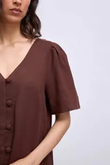 Vestido corto negro de lino con escote en V y abotonadura frontal.