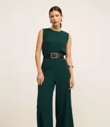 Mono pantalón largo color verde oscuro, sin mangas y con cuello redondo. Presenta abertura en forma de gota en la espalda y corte palazzo.