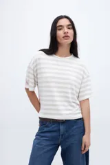 Remera holgada a rayas horizontales color crudo y beige, con mangas cortas y tajos laterales.