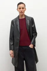 Blazer de mujer color negro, confeccionado en eco cuero, con solapas anchas, cierre frontal de un solo botón y pespuntes visibles.