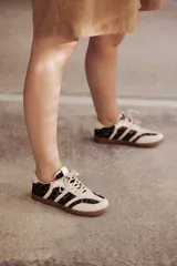 Zapatillas Adidas Samba con estampado animal print en blanco y negro, detalles en cuero beige y suela de goma color caramelo.