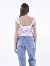 Blusa blanca con escote cuadrado y detalles de lazada al frente, de corte ajustado.