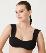 Blusa musculosa cropped de punto negro con escote corazón y textura acanalada.