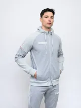 Campera con capucha Umbro de piqué, color gris con mangas negras y logo bordado en blanco.