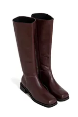 Botas de cuero de caña alta, con punta cuadrada y taco bajo. Disponibles en color bordó y negro.