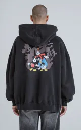 Buzo con capucha de calce oversize, color negro, con un pequeño estampado de Mickey Mouse en el pecho derecho. El cordón de ajuste de la capucha es negro con texto repetido en blanco.