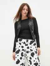 Chaleco negro de diseño ajustado con botones frontales.