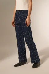 Pantalón de jean azul oscuro con estampado de corazones blancos, corte ancho y tiro alto.
