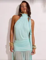 Vestido largo color celeste, con cuello alto y tirantes anchos que se anudan en el cuello. Presenta fruncido en la cintura y falda con transparencias.