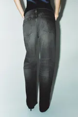 Jeans de tiro medio color azul oscuro, corte wide leg, con trabillas y cinco bolsillos. Cierre frontal con cremallera y botón metálico.