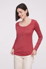 Remera de manga larga entallada en color blanco, confeccionada en algodón. Presenta cuello redondo con una hilera de botones frontales y un pequeño bolsillo en el pecho con detalle de botón.