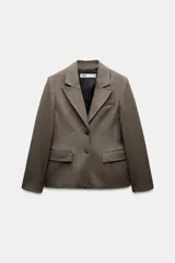 Blazer marrón con estampado de cuadros, cuello solapa de muescas y manga larga con hombreras acabada en abertura y botones. Bolsillos con solapa en delantero y de vivo en pecho. Forro interior. Cierre frontal con botones.