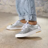 Zapatillas deportivas plateadas acordonadas, confeccionadas en cuero vacuno tanto en su exterior como en su interior. Suela de goma blanca con detalle marrón en el talón. Horma de punta redonda y cómoda.