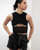Top negro sin mangas con diseño cruzado en el frente y abertura en el abdomen con detalle de microtul.