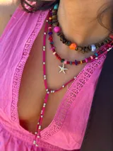 Collar corto con escallones de ojo de tigre y cuentas de colores intercaladas. Se cierra con cadena de acero quirúrgico y ganchito para regular el largo.