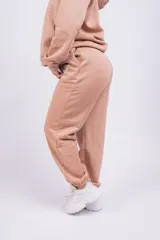 Pantalón de jogging color beige con cintura elástica y logo bordado en la pierna.
