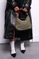 Bolso negro de nylon con textura sutil y manija fruncida.