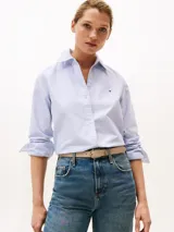 Camisa celeste a rayas verticales blancas, de corte amplio, con cuello inglés y logo bordado en el pecho.