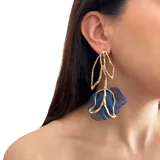 Aros colgantes con forma de flor, con pétalos de tela color gris y estructura de metal dorado.