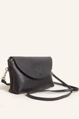 Cartera tipo sobre de cuero vacuno, con solapa frontal, cierre y broche magnético. Incluye correa larga ajustable y extraíble para usar como bandolera.