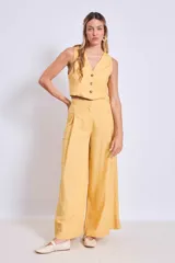 Pantalón ancho de tiro alto color amarillo mostaza, con pliegues frontales y bolsillos cargo a los lados.