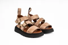 Sandalias de cuero color beige con plataforma de goma negra, tiras anchas con hebillas ajustables y tira trasera con velcro.