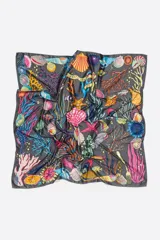 Pañuelo cuadrado con estampado de motivos marinos sobre fondo rojo.