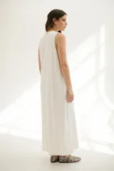 Vestido largo azul con cuello redondo y sisas con ribete color beige.