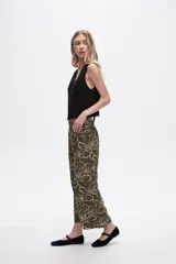 Pantalón capri negro con estampado floral en color crema, de corte ancho y tiro alto.