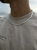 Cadena de eslabones tipo cubana o curb, de color plateado, con acabado brillante.