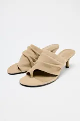 Sandalia tipo mule color beige, de ante, con tacón fino medio y tira ancha con efecto arrugado.